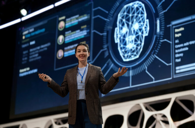 A woman is speaking on stage about the future of AI technologies.